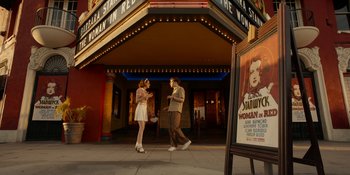 Movie still from “Café Society” (2016), directed by Woody Allen – A man and a woman walking in front of a movie theater; Wide shot, Low angle