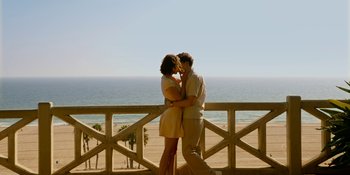 Movie still from “Café Society” (2016), directed by Woody Allen – A man and a woman standing next to each other on a beach; Wide shot, High angle
