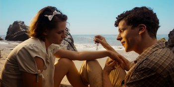 Movie still from “Café Society” (2016), directed by Woody Allen – A man and a woman sitting on the beach; Close Up shot, High angle