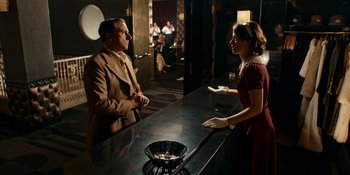 Movie still from “Café Society” (2016), directed by Woody Allen – A man and a woman standing at a counter; Medium shot, Over the shoulder angle