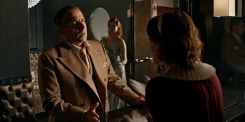 Movie still from “Café Society” (2016), directed by Woody Allen – A man in a suit talking to a woman in a dress; Medium shot, Over the shoulder angle