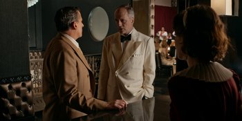Movie still from “Café Society” (2016), directed by Woody Allen – Two men in tuxedos talking to each other in front of a mirror; Medium shot, Over the shoulder angle