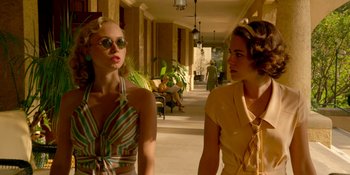 Movie still from “Café Society” (2016), directed by Woody Allen – Two young women walking down a walkway in a building; Medium shot, Low angle