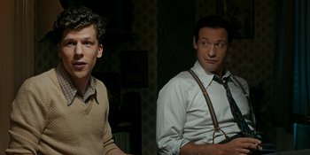 Movie still from “Café Society” (2016), directed by Woody Allen – Two men sitting next to each other in front of a wall; Medium shot, Over the shoulder angle