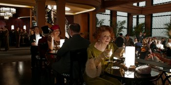 Movie still from “Café Society” (2016), directed by Woody Allen – A group of people sitting at a table drinking wine; Medium shot, Over the shoulder angle