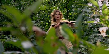 Movie still from “Café Society” (2016), directed by Woody Allen – A woman holding a knife in a forest; Medium shot, Low angle