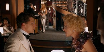 Movie still from “Café Society” (2016), directed by Woody Allen – A man and a woman in formal wear at a party; Medium shot, Over the shoulder angle