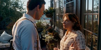 Movie still from “Café Society” (2016), directed by Woody Allen – A man and a woman standing next to each other outside; Medium shot, Low angle