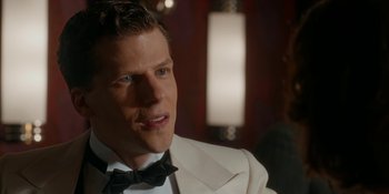 Movie still from “Café Society” (2016), directed by Woody Allen – A person wearing a suit and bow tie; Close Up shot, Over the shoulder angle