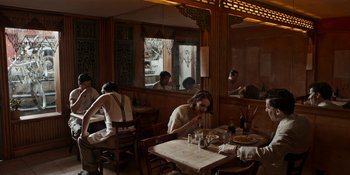 Movie still from “Café Society” (2016), directed by Woody Allen – A group of people sitting at a table in a restaurant; Wide shot, High angle