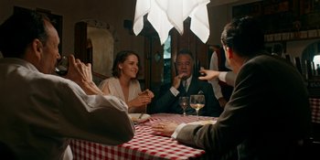 Movie still from “Café Society” (2016), directed by Woody Allen – A group of people sitting at a table with wine glasses; Medium shot, High angle
