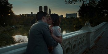 Movie still from “Café Society” (2016), directed by Woody Allen – A man and a woman kissing in front of a city skyline; Medium shot, High angle