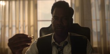 Movie still from “Fargo” (2014), created by Noah Hawley – A person sitting in a chair wearing a tie; Close Up shot, Over the shoulder angle