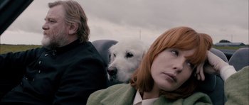 Movie still from “Calvary” (2014), directed by John Michael McDonagh – Two women and a white dog sitting next to each other; Close Up shot, Over the shoulder angle