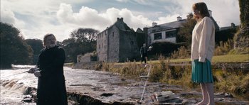 Movie still from “Calvary” (2014), directed by John Michael McDonagh – A man standing next to a body of water; Extreme Wide shot, High angle