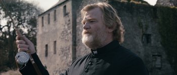 Movie still from “Calvary” (2014), directed by John Michael McDonagh – A man with long hair and a beard wearing a priest's outfit; Close Up shot, Low angle