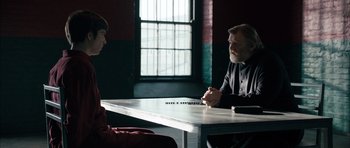 Movie still from “Calvary” (2014), directed by John Michael McDonagh – Two people sitting at a table in front of each other; Medium shot, Over the shoulder angle