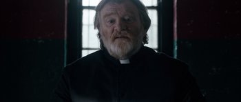 Movie still from “Calvary” (2014), directed by John Michael McDonagh – An old man with a beard wearing a priest's outfit; Close Up shot, Low angle