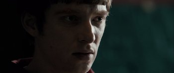 Movie still from “Calvary” (2014), directed by John Michael McDonagh – A young man's face with dark lighting; Close Up shot, Over the shoulder angle