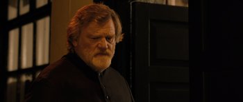 Movie still from “Calvary” (2014), directed by John Michael McDonagh – An older man with a beard and a mustache; Close Up shot, Over the shoulder angle
