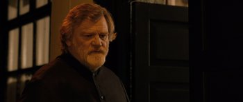 Movie still from “Calvary” (2014), directed by John Michael McDonagh – A man with a beard and a black shirt; Close Up shot, Low angle