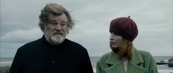 Movie still from “Calvary” (2014), directed by John Michael McDonagh – A man and a woman standing next to each other on the beach; Close Up shot, Low angle