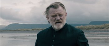 Movie still from “Calvary” (2014), directed by John Michael McDonagh – An old man with a beard and a black jacket; Close Up shot, Low angle