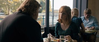 Movie still from “Calvary” (2014), directed by John Michael McDonagh – A woman sitting at a dinner table with a man; Medium shot, Over the shoulder angle