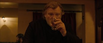 Movie still from “Calvary” (2014), directed by John Michael McDonagh – An older man holding a wine glass in his right hand; Close Up shot, Low angle