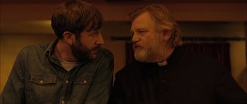 Movie still from “Calvary” (2014), directed by John Michael McDonagh – Two men talking to each other in a room; Close Up shot, Over the shoulder angle
