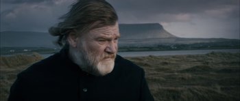 Movie still from “Calvary” (2014), directed by John Michael McDonagh – An old man with a beard and a black jacket; Close Up shot, Over the shoulder angle