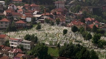 Movie still from “Cameraperson” (2016), directed by Kirsten Johnson – An aerial view of a cemetary in a city; Extreme Wide shot, High angle
