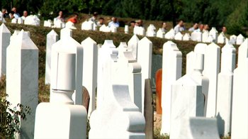 Movie still from “Cameraperson” (2016), directed by Kirsten Johnson – A group of people standing around a cemetery; Extreme Wide shot, High angle