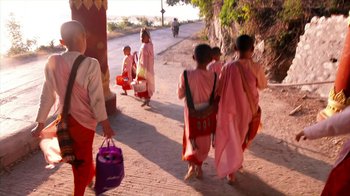 Movie still from “Cameraperson” (2016), directed by Kirsten Johnson – A group of people walking down a street; Medium shot, Low angle