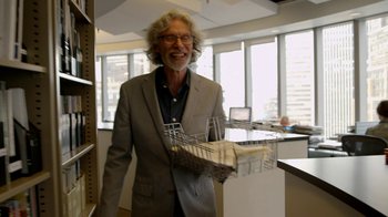 Movie still from “Cameraperson” (2016), directed by Kirsten Johnson – An older man in a suit holding an object in his hand; Medium shot, Low angle