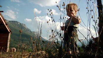 Movie still from “Cameraperson” (2016), directed by Kirsten Johnson – A little boy standing in a field of flowers; Wide shot, Low angle