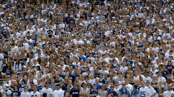 Movie still from “Cameraperson” (2016), directed by Kirsten Johnson – A large group of people are gathered in a stadium; Extreme Wide shot, Overhead angle