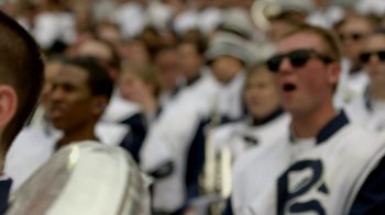 Movie still from “Cameraperson” (2016), directed by Kirsten Johnson – A group of people standing in a crowd of people; Extreme Close Up shot, High angle