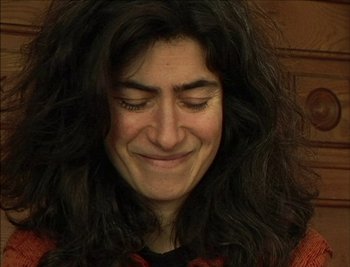 Movie still from “Cameraperson” (2016), directed by Kirsten Johnson – A person with long black hair; Close Up shot, High angle