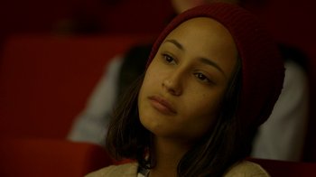 Movie still from “Cameraperson” (2016), directed by Kirsten Johnson – A woman with a red hat is sitting in a chair; Close Up shot, Over the shoulder angle