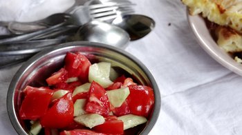 Movie still from “Cameraperson” (2016), directed by Kirsten Johnson – A metal bowl filled with tomatoes and cucumber slices; Extreme Close Up shot, Overhead angle