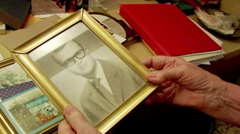 Movie still from “Cameraperson” (2016), directed by Kirsten Johnson – A person holding a picture of a man in a suit; Extreme Close Up shot, Overhead angle
