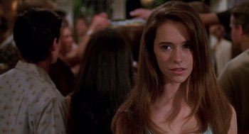 Movie still from “Can't Hardly Wait” (1998), directed by Deborah Kaplan – A woman with long brown hair standing in front of a group of people; Close Up shot, Over the shoulder angle