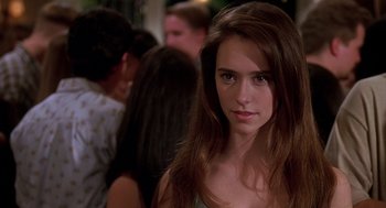 Movie still from “Can't Hardly Wait” (1998), directed by Deborah Kaplan – A woman with long brown hair standing in front of a group of people; Close Up shot, Over the shoulder angle