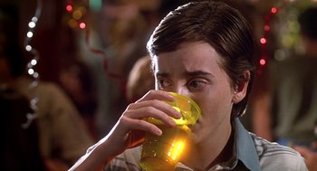 Movie still from “Can't Hardly Wait” (1998), directed by Deborah Kaplan – A young man drinking a glass of beer at a party; Close Up shot, Over the shoulder angle