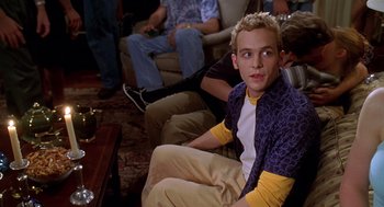 Movie still from “Can't Hardly Wait” (1998), directed by Deborah Kaplan – A man sitting on a chair in a room; Medium shot, Low angle