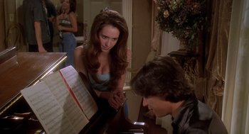 Movie still from “Can't Hardly Wait” (1998), directed by Deborah Kaplan – A man and a woman are playing a piano together; Medium shot, Over the shoulder angle