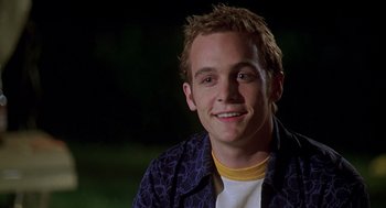 Movie still from “Can't Hardly Wait” (1998), directed by Deborah Kaplan – A young man smiles for the camera; Close Up shot, Low angle