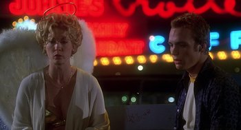 Movie still from “Can't Hardly Wait” (1998), directed by Deborah Kaplan – A man and a woman standing next to each other in front of a neon sign; Medium shot, Low angle