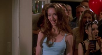 Movie still from “Can't Hardly Wait” (1998), directed by Deborah Kaplan – A woman with long brown hair smiling for the camera; Close Up shot, Over the shoulder angle
